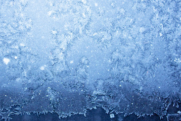 Frozen morning window, blurred ice blue background