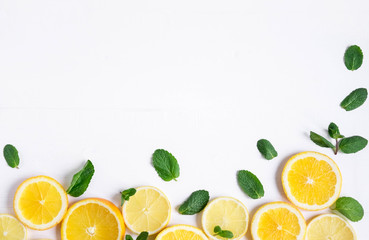 White background with lemon, orange slices and mint. Concept with fresh fruit. Lemon, Orange, Mint. View from above.