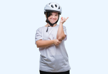 Young adult cyclist woman with down syndrome wearing safety helmet over isolated background with a big smile on face, pointing with hand and finger to the side looking at the camera.