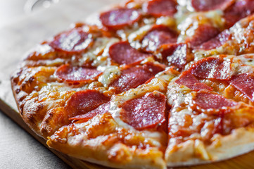 Pepperoni Pizza with Mozzarella cheese, salami, Tomatoes, pepper. Italian pizza on wooden table background
