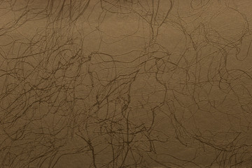 Imitation leather of gold color with dark streaks. Texture for background and design.