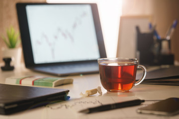 An image of a morning, office desk of a financial analyst close-up.