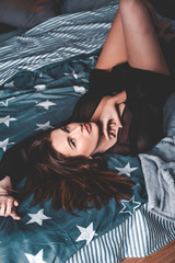 Fototapeta premium Beautiful girl posing in the bedroom on the bed