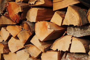 Background of stacked, dry chopped logs used for firewood