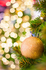 Glittering Baubles with Glowing Sparkling Gold defocused Light (bokeh) Illumination background with decorated Christmas Tree. Special Holidays, Festival design decoration, New Year Celebration, Party.