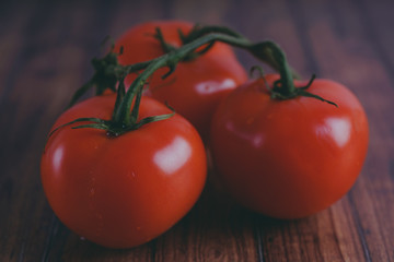 Red, juicy tomatoes on wooden background, concept: fresh vegetables, healthy food.