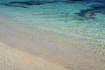 Obraz premium Closeup photo of ocean water, sand and reef close to the beach