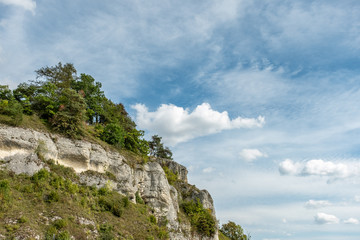Naklejka premium Bewaldete Felswand mit Wolkenhimmel auf der schwäbischen Alb