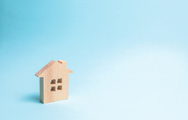 Wooden house on a blue background. The concept of affordable housing and mortgages to buy a house....