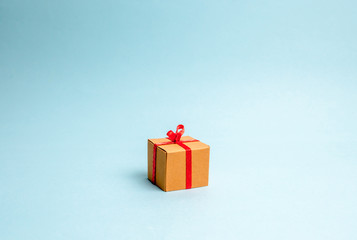 Gift box on blue background. Minimalism. The approach of the New Year holidays or birthday. Sale of gifts, special promotion, marketing and advertising. Donation concept.