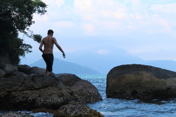 The boy walking on the rocks