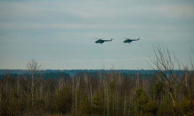Helicopter in flight at sunset above war field