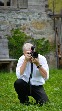 fotograf in der Hocke beim arbeiten im freien 