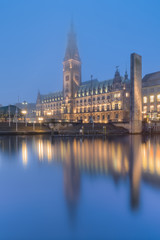 The City Hall (Rathaus) of Hamburg, Germany, in the fog at dusk.