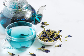 Obraz na płótnie Canvas Butterfly pea flower blue tea in a cup with teapot. Healthy detox herbal drink