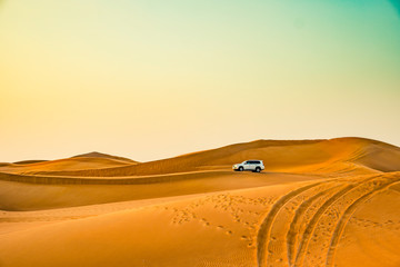 Fototapeta na wymiar Jeep riding on sand at the desert with dunes