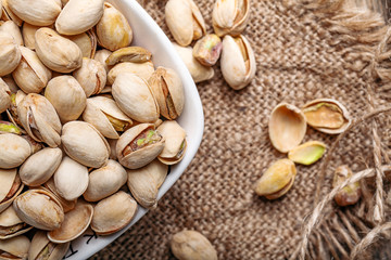 Some whole Pistachios (selective focus; close-up shot) on wooden background top view