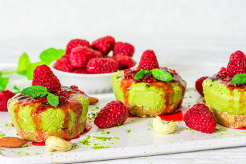 green matcha vegan raw cakes with raspberries, mint and nuts. healthy delicious food