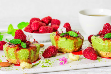 matcha green tea vegan raw cheesecakes with raspberries, mint, nuts and flowers. healthy delicious food