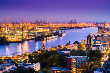 Naklejka premium Aerial view of downtown Hamburg, Germany with the river Elbe, the harbor and the Harbor District at dusk.