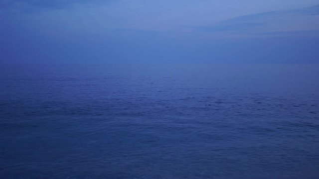 Dark blue evening peaceful sea and sky background. Beautiful moody marine landscape with copyspace. Real time 4k video footage.