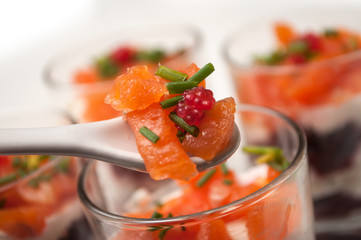 closeup of beet and salmon appetizers in little glasses on white background
