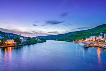 Fototapeta na wymiar The river Moselle and Bernkastel-Kues, Germany, at dusk. The twin town of Bernkastel-Kues is regarded as the most popular town and center of the Middle Moselle.