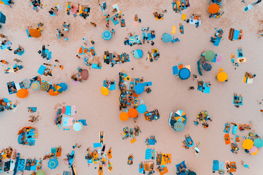 Aerial view of people sunbathing at a beautiful beach in Portugal; Concept for summer vacations