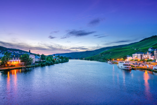 The river Moselle and Bernkastel-Kues, Germany, at dusk. The twin town of Bernkastel-Kues is regarded as the most popular town and center of the Middle Moselle.