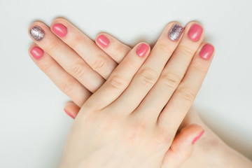 Hands with long artificial manicured nails colored with red nail polish