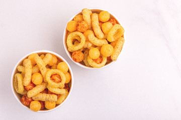 Assorted puff corn snacks in two paper cup