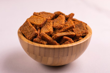 Rye salted crackers in wooden bowl on light marble background