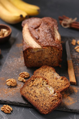 Homemade banana bread with walnut and cinnamon on a dark background