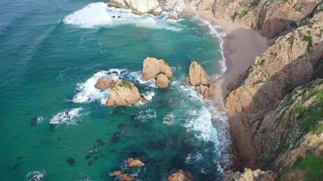 West Portugal coastline aerial flight over Ursa beach with rocks sticking out of the water