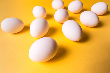 White eggs pattern over yellow pastel background. Front view. Isometric view.