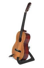 Acoustic guitar on stand against white background