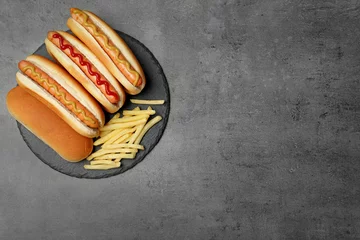 Tuinposter Delicious hot dogs and french fries on grey background, top view. Space for text © New Africa