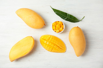 Flat lay composition with mango on wooden background