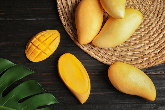 Flat lay composition with mango on wooden background