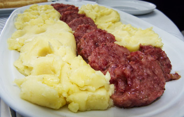 Cotechino, pork sausage, with mashed potato in a white plate, italian food 