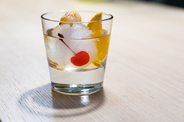 Homemade special interpretation of classic Old Fashioned Cocktail, made in an Ice Ball with orange and cinnamon flavored sugar burning on top