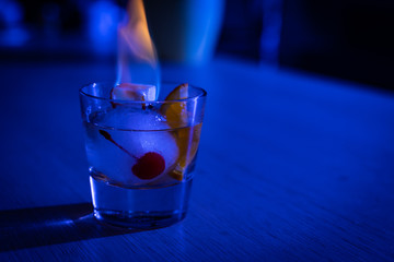 Homemade special interpretation of classic Old Fashioned Cocktail, made in an Ice Ball with orange and cinnamon flavored sugar burning on top
