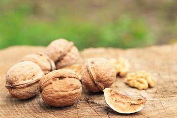 A few walnuts on a wooden surface. A broken nut with a shell and a kernel. Autumn harvest. Close-up. View from above.
