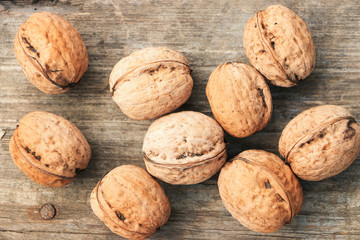 A few walnuts on a wooden surface. Autumn harvest. Close-up. View from above.