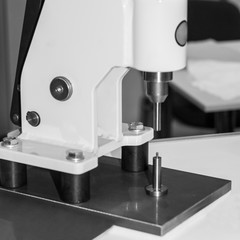 White hand press to set rivets on the table