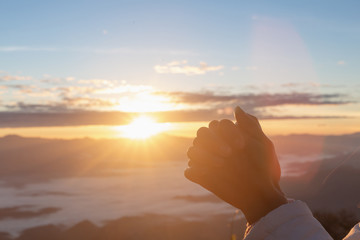 Christian woman  hands praying to god on the mountain background with morning sunrise. Woman Pray...