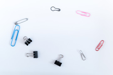 Different kinds of paper clips on white background. Illustration of diversity through objects.