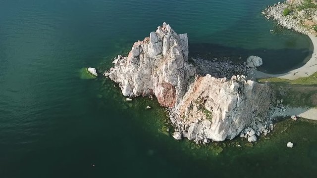 Tranquil Aerial View of the Baikal Bay Shamanka. White ship in calm bay at great lake. Olkhon Island, Baikal, Russia, Siberia. Drone footage.