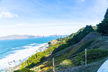 The view of golden gate bridge in Lands end at San Francisco- San Francisco. summer , cloud , rock , sea, plant.