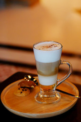 latte macchiato coffee Served with cookie in brown earth tone color background and have some space for write wording